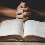 book and hands on table