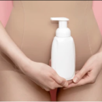 Close-up of a woman holding a bottle of feminine vaginal wash, designed to combat vaginal dryness and itching.