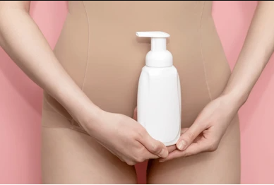 Close-up of a woman holding a bottle of feminine vaginal wash, designed to combat vaginal dryness and itching.