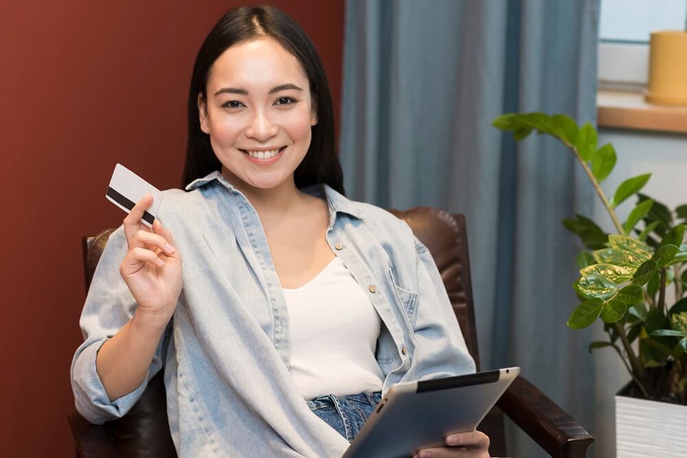 girl smiling and hold credit card