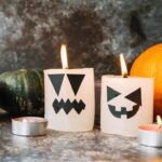 burning-candles-halloween-style-standing-with-pumpkins-background_23-2147895070