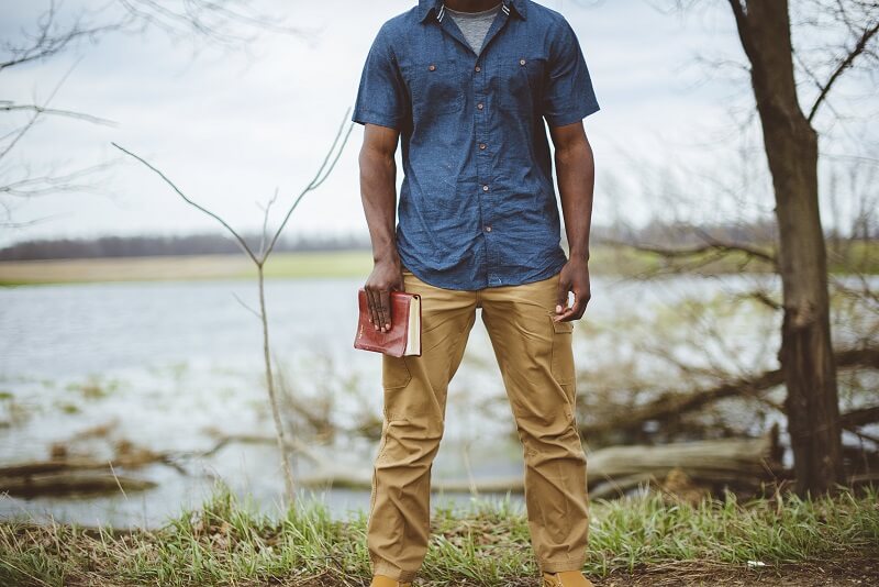 man standing and hold a book in his hand